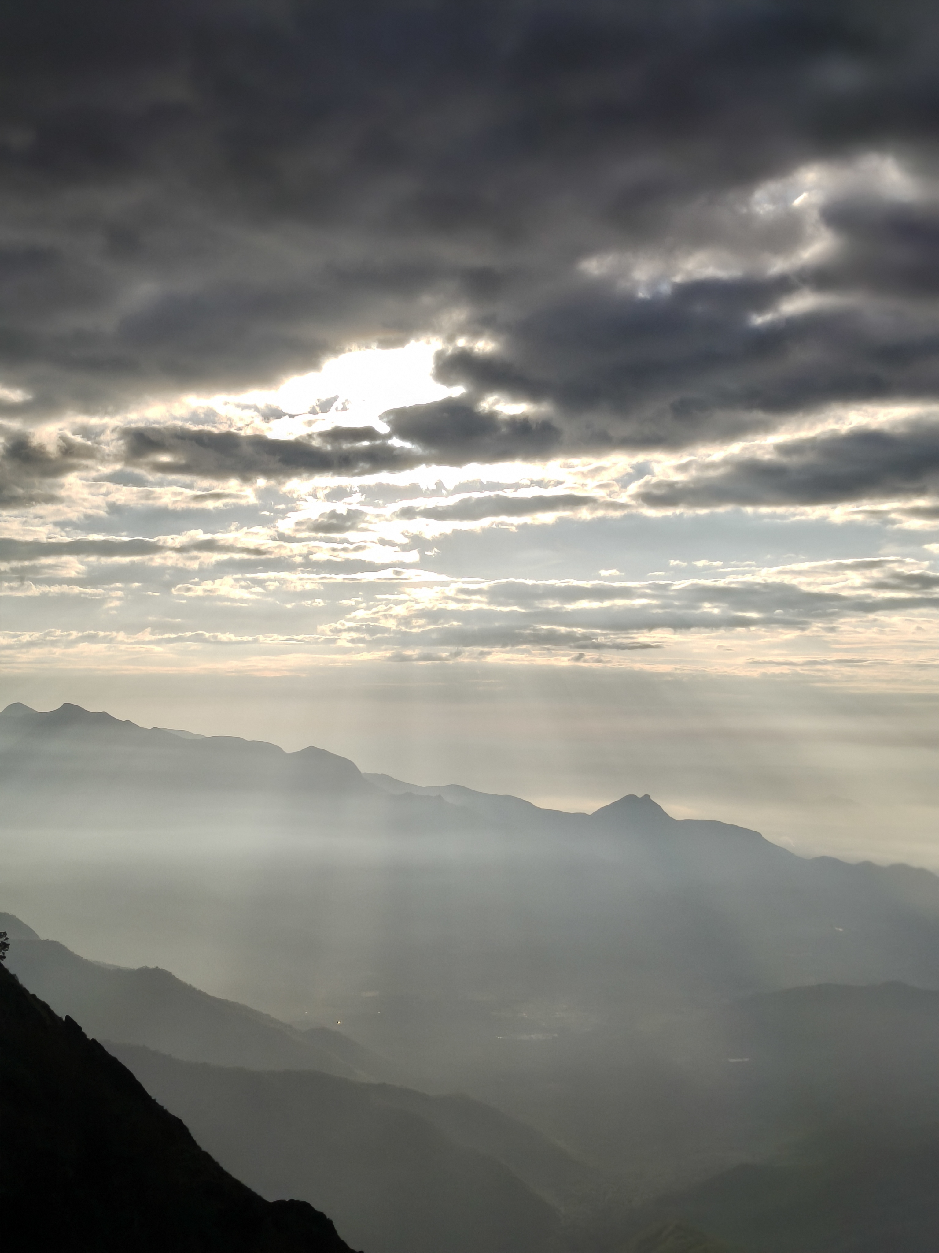Kolukkumalai morning fog covering tea plantations with rising sun in the background